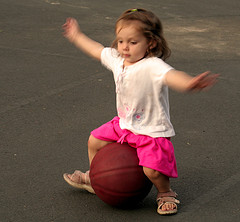 Little girl trying to balance on a ball (Photo by Sharon Mollerus on Flickr)